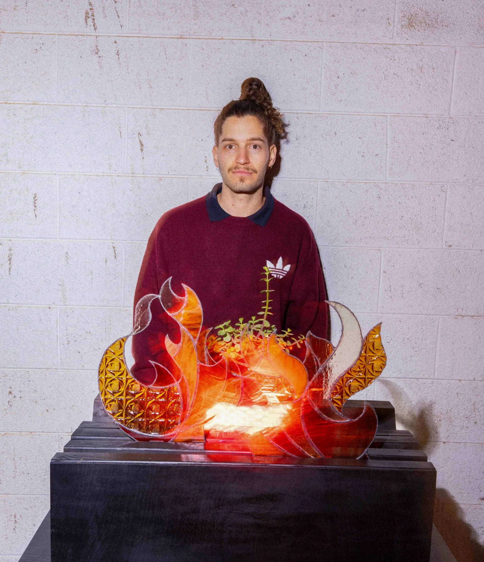 Yuval standing behind his illuminated stained-glass Burning Bush installation