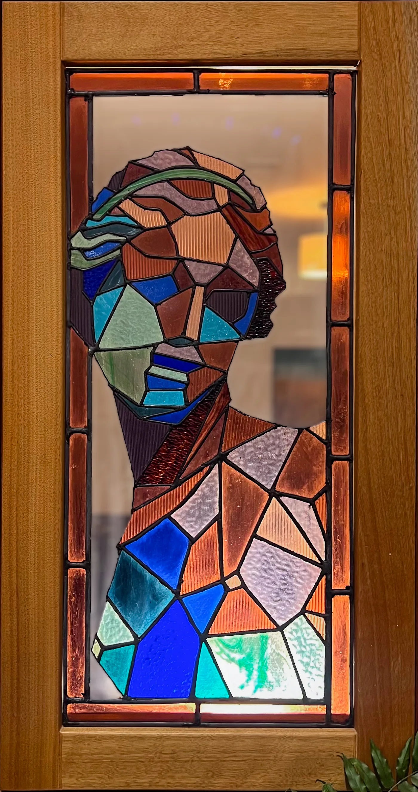 Faceted stained-glass portrait in a wooden frame